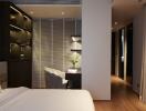 Modern bedroom with wooden flooring, built-in shelves, a desk, and nightstands with lighting