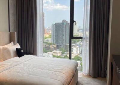 A modern bedroom with a large window overlooking the city.