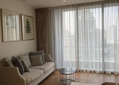Living room with sofa, coffee table, large window with city view