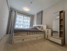 Spacious bedroom with a double bed, large window, and storage solutions.