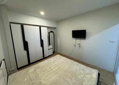 Modern bedroom with wardrobe and wall-mounted TV