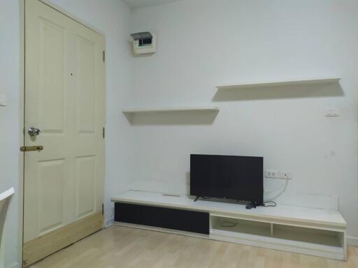 Minimalist living room with wall-mounted TV and shelves