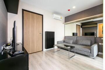 Modern living room with a gray sofa and flat-screen TV