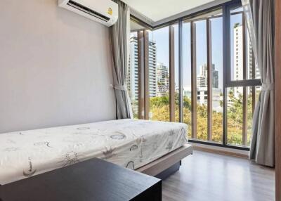 Bedroom with a large window and a scenic city view