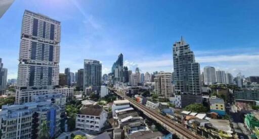 City skyline with multiple high-rise buildings under a clear blue sky