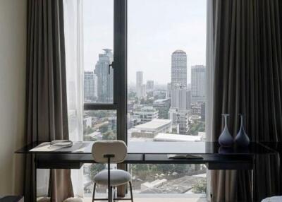 Bedroom with a desk, chair, and a city view from a large window
