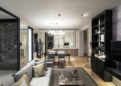 Modern living room with adjacent kitchen featuring stylish decor and bookshelves