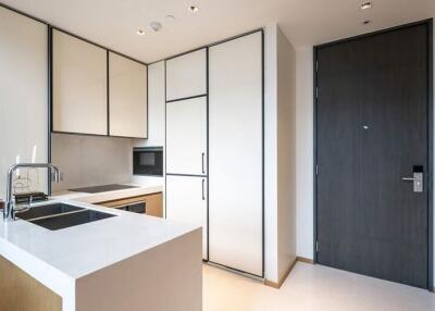 Modern kitchen with white cabinets, integrated appliances, and a sink