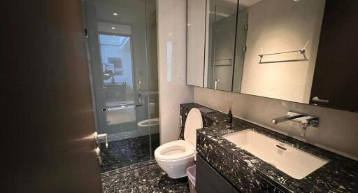 Modern bathroom with black marble countertops and enclosed shower