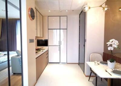 Modern kitchen adjacent to dining area with view into bedroom