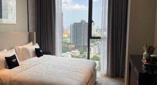 Modern bedroom with a large window offering a panoramic city view