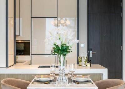 Modern dining area with a set table and adjacent kitchen