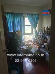 Bedroom with a small altar and window draped with blue curtains