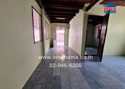 Hallway with light green walls and tiled floor