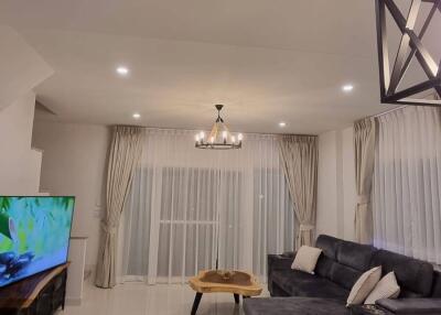 Spacious living room with modern furniture and a large flat-screen TV