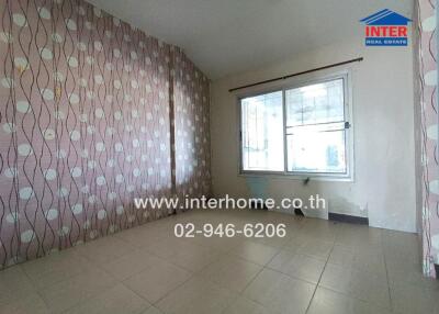 Empty bedroom with tiled floors and patterned wallpaper