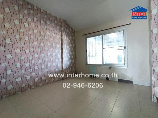 Empty bedroom with tiled floors and patterned wallpaper