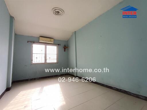 Empty bedroom with tiled floor and air conditioning unit