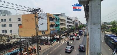 Street view in front of building with visible traffic and nearby establishments