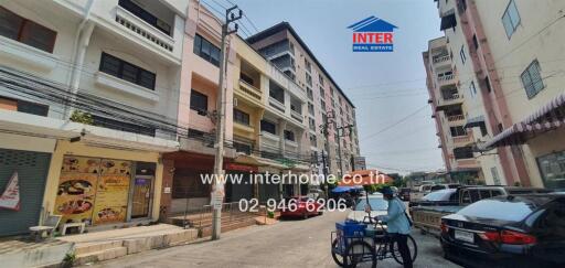 Street view of various buildings with a real estate agency sign