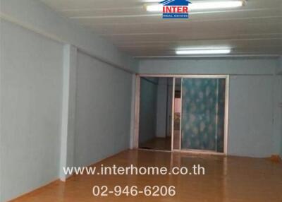 Empty living space with wooden flooring and frosted glass sliding door