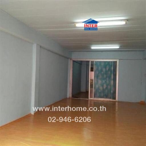 Empty living space with wooden flooring and frosted glass sliding door