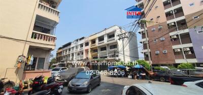 Street view of apartment buildings with parked vehicles