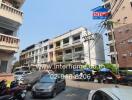 Street view of apartment buildings with parked vehicles