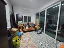 Main living space with sliding glass doors and various items including boxes and a computer setup