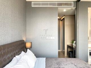 Modern bedroom with upholstered headboard and wall-mounted air conditioner