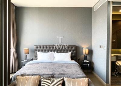 Modern bedroom with gray color scheme, a large bed, and ambient lighting