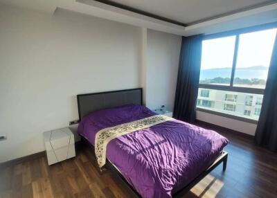 Modern bedroom with wooden flooring and a large window