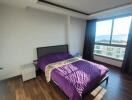 Modern bedroom with wooden flooring and a large window