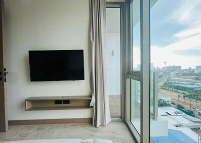 Bedroom with wall-mounted TV and balcony view