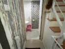 Small bathroom accessed via narrow hallway with stairs