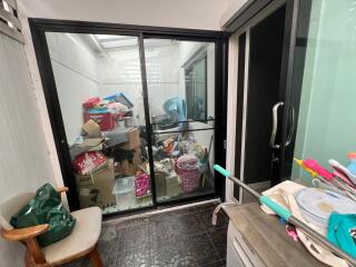 Cluttered utility room with glass sliding doors and miscellaneous items