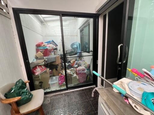 Cluttered utility room with glass sliding doors and miscellaneous items
