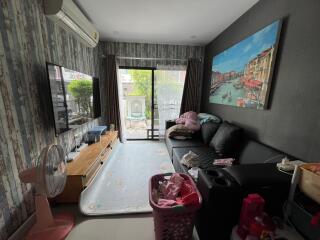 Living room with sofa, TV, air conditioner, and sliding glass door