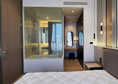 Modern bedroom with glass-enclosed bathroom and stylish furnishings