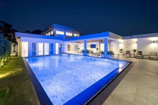 Modern luxury villa with illuminated pool at night