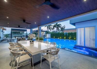 Outdoor dining area near a swimming pool with lounge chairs