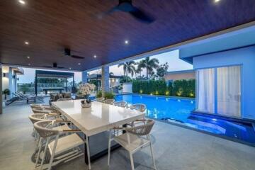 Outdoor dining area near a swimming pool with lounge chairs