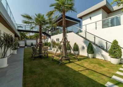 Modern backyard with palm trees and glass railings