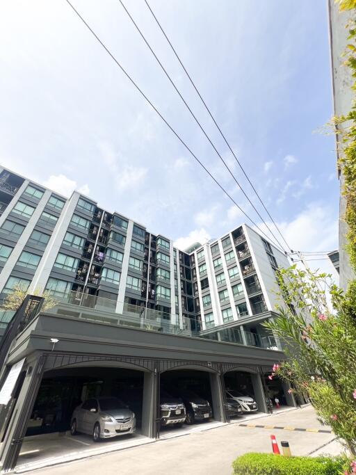 Exterior view of a modern apartment building with parking spaces