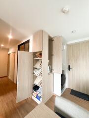Open storage cabinet with shoes and miscellaneous items at entrance area