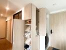 Open storage cabinet with shoes and miscellaneous items at entrance area