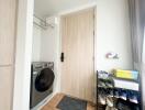 Entryway with washer, shoe rack, and light wood door