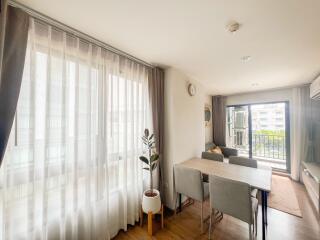 Bright and modern living space with large windows, dining area, and cozy seating area