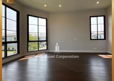 Spacious living room with large windows and dark wood flooring