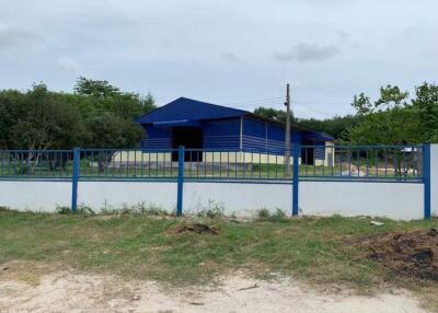 Blue industrial building with surrounding fence